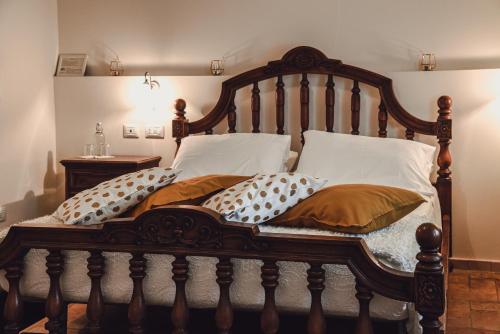 a bedroom with a wooden bed with pillows at Masseria del Vino in Loreto Aprutino