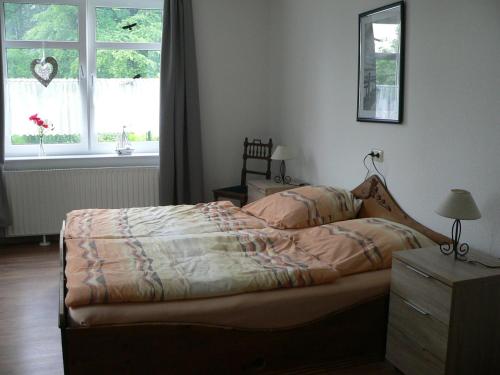 a bedroom with a bed and a window at Ferienwohnung Zum grünen Holz in Bohlenberge