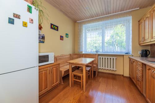 una cucina con tavolo e frigorifero di Vila Arona a Palanga