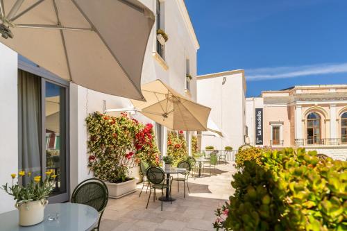 a patio with tables and chairs and an umbrella at Palazzo Indelli in Monopoli