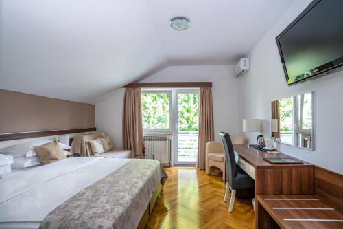 Schlafzimmer mit einem Bett, einem Schreibtisch und einem TV in der Unterkunft Rooms Degenija Annex in Selište Drežničko