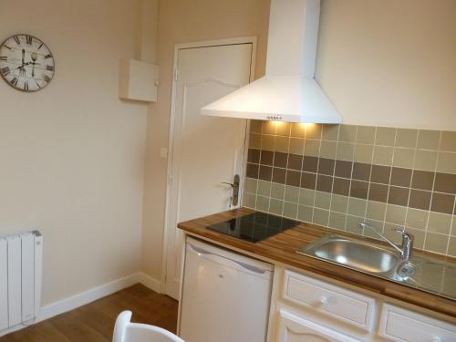 a kitchen with a sink and a clock on the wall at Etape Zen in Illiers