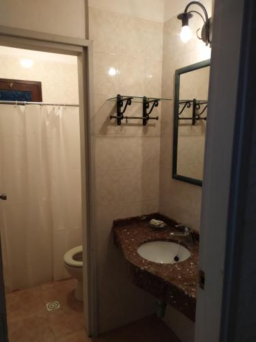 La salle de bains est pourvue d'un lavabo, de toilettes et d'un miroir. dans l'établissement Casa Roja, à Playa Verde