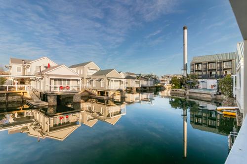 a view of a river with houses and buildings at Avocet Nest on Thesen Island in Knysna