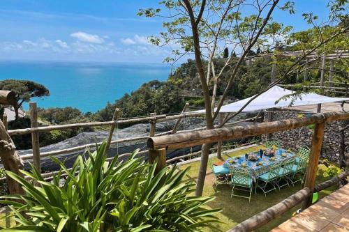 a table and chairs with the ocean in the background at L'Olearia Luxury Country Villa in Amalfi Coast in Maiori