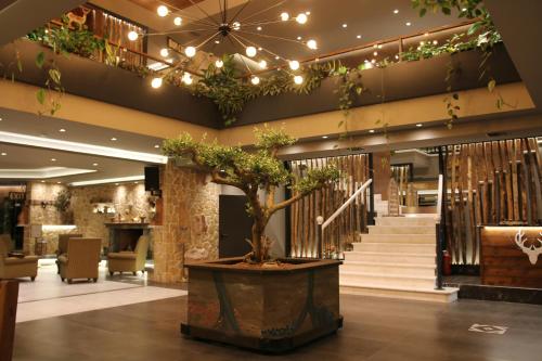 a lobby with a potted tree in the middle of a building at Anthidon Nature Estate & Farm in Chalkida