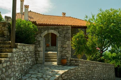 ein Steinhaus mit einem Torbogen und einer Steinmauer in der Unterkunft Arcadianis Villa at Psari Trikolonon Gortynia in Psárion