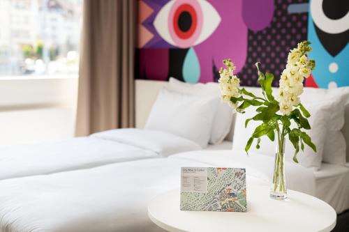 a vase of flowers on a table in a hotel room at B&B HOTEL St Gallen in St. Gallen