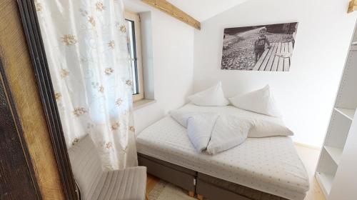 a small bedroom with a bed and a window at Appartements "Da Zillertaler und die Geigerin" in Mayrhofen