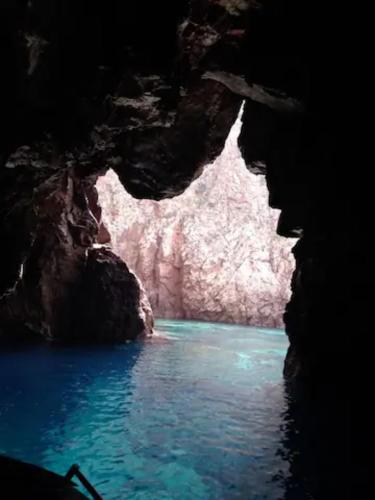 a cave with blue water and rocks in it at Buggerru fuori dal tempo in Buggerru