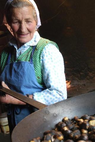 a woman is holding a large pan of food at Parkhotel Post in Chiusa