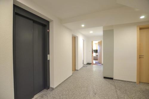 a hallway with a black door in a building at Stella 5 in Riederalp