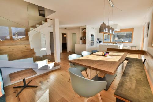 費爾施的住宿－Milachra Penthouse，厨房以及带木桌和椅子的用餐室。