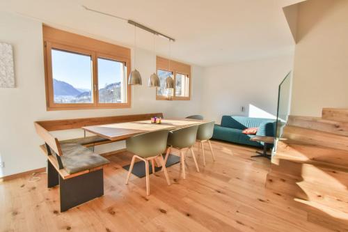 a living room with a dining room table and chairs at Milachra Penthouse in Fiesch