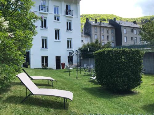 a group of benches in the grass in front of a building at Les Montagnettes in Le Mont-Dore