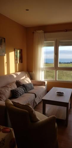 フォスにあるApartamento en playa de Fozのベッドルーム1室(ベッド1台、ソファ、テーブル付)