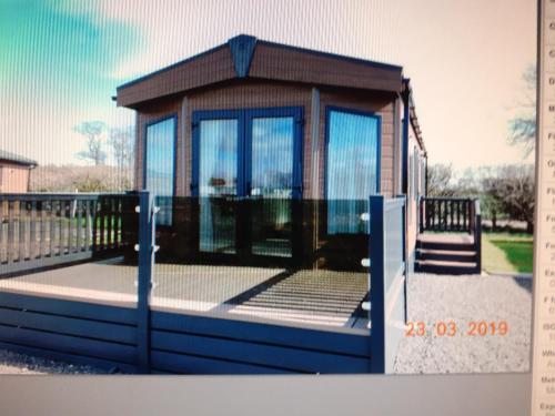 a small house with glass doors on a deck at 11 The Meadoows in Hirn