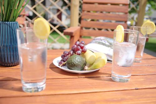 a table with a plate of fruit and glasses of water at Blarmore Apartment Inverness in Inverness