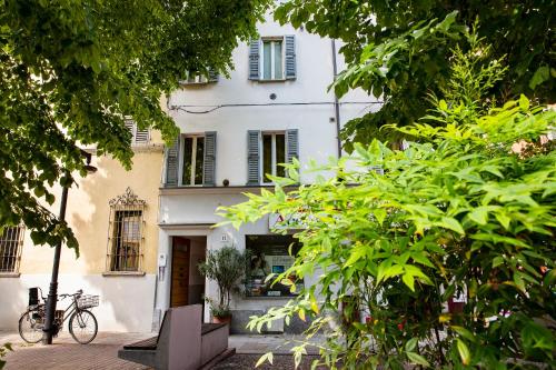 a white building with a bike parked in front of it at B&B AL DUCALE and APARTMENTS in Parma
