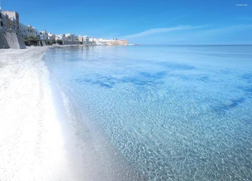 
a beach with a clear blue sky and a blue ocean at Ai Lumi in Trapani
