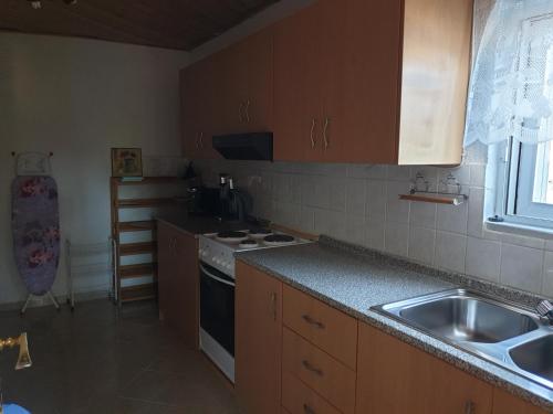 a kitchen with a sink and a stove top oven at Paradis Studios in Archangelos