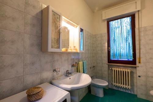 uma casa de banho branca com um lavatório e um WC em Edera Silvi Vacanza em Silvi Marina