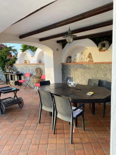 a wooden table and chairs on a patio at Dimorra Sun and Relax in Ischia