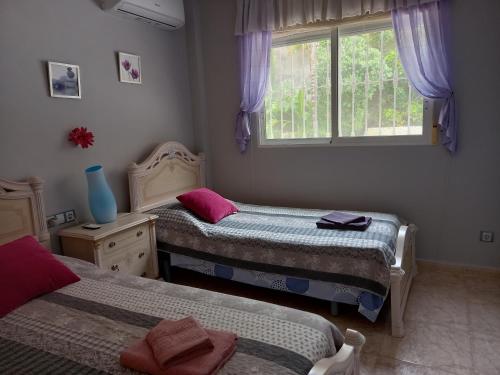 a bedroom with two beds and a window at Villa Casa Kenaz in El Campello