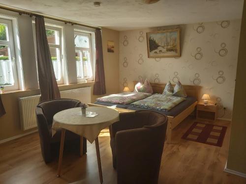 a living room with a bed and a table and chairs at Ferienapartmenthaus am Rittertor in Stolberg i. Harz