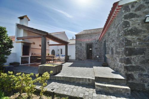 an external view of a house with a stone wall at Charming green country house in Laseira