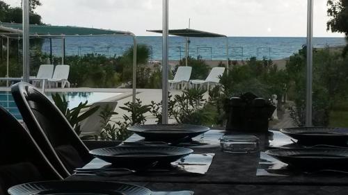 a table with chairs and a view of the ocean at Hotel Grün in Kızılot