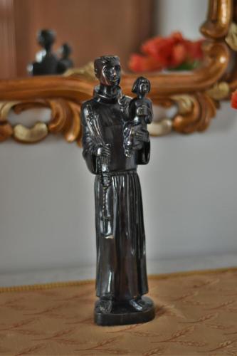 a bronze figurine of a man holding achild at Charming green country house in Laseira