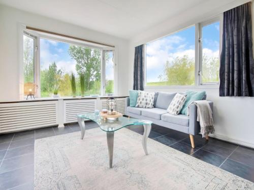 een woonkamer met een bank en een glazen tafel bij Fantastic villa in Ooltgensplaat with jetty in Ooltgensplaat