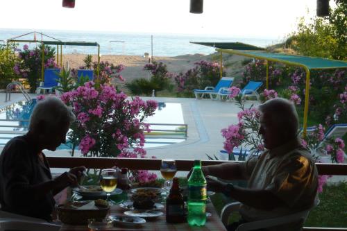 two people sitting at a table with drinks at Hotel Grün in Kızılot