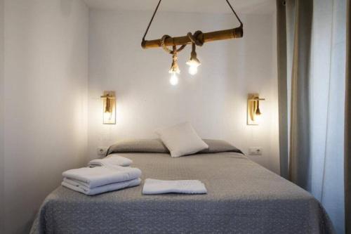 1 dormitorio con 1 cama con 2 toallas en Vivienda turística Lagarto de Jaén, en Jaén