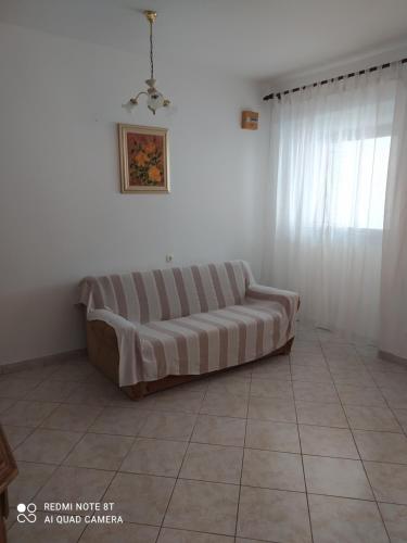 a couch sitting in a living room next to a window at Apartments Katica in Metajna
