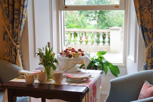 a table with a bowl of fruit on it next to a window at Bedford House & Hall in Balbriggan