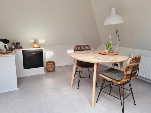 jadalnia ze stołem i krzesłami oraz telewizorem w obiekcie B&B Onderderietenkap w mieście Heerde