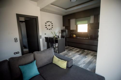 a living room with a couch and a kitchen at Paraiso Azul Villas in Áyios Dhimítrios