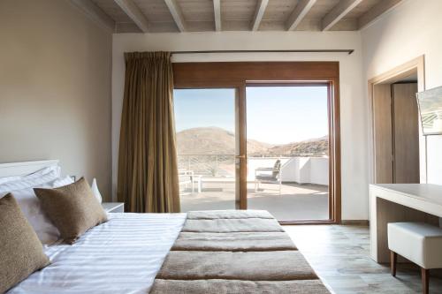 um quarto com uma cama e uma grande janela em Villa Angelica Meronas em Méronas