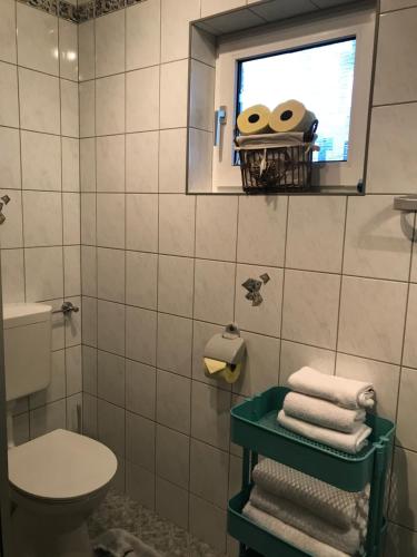 a bathroom with a toilet and a window and towels at Landhaus Schönblick in Radenthein
