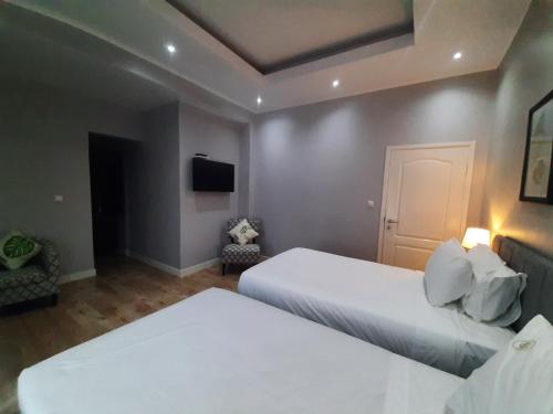 a hotel room with two beds and a tv at Terra Guest House in Maputo