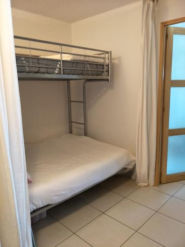 Ce lit superposé se trouve dans un dortoir doté d'une fenêtre. dans l'établissement Appartement face à la plage, à Saint-Raphaël