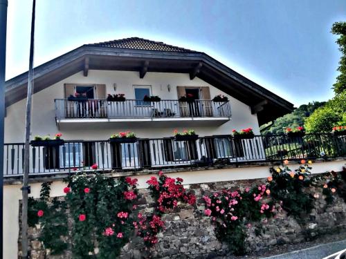 a white house with flowers on the balconies at Versigglhof in Appiano sulla Strada del Vino
