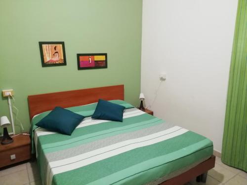 フォンターネ・ビアンケにあるLa Sorgenteのベッドルーム1室(青と緑の枕が備わるベッド1台付)