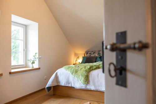 a bedroom with a bed and a window at VILLA zeitlos - PfauenAuge in Traunstein