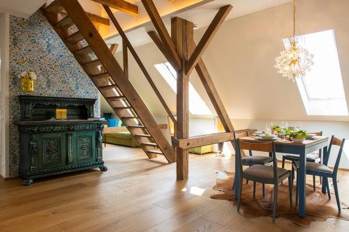 a dining room with a green table and a staircase at VILLA zeitlos - PfauenAuge in Traunstein