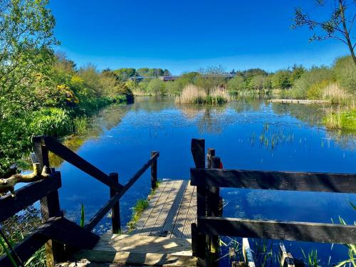 a view of a river with a wooden bridge at Shepherd's Loch Glamping in Turriff
