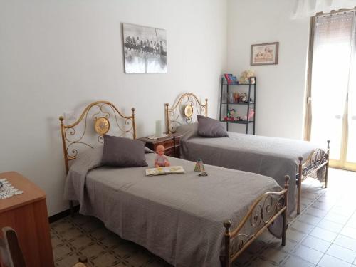 a room with two beds and a table at La casa di GB in Pieve di Teco