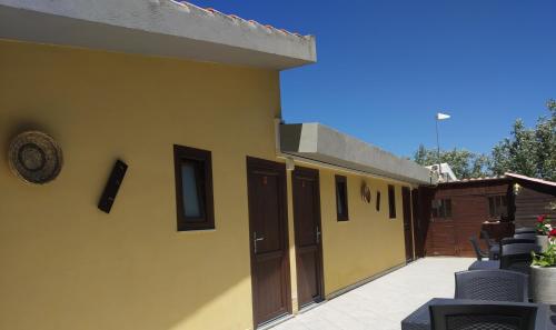 a yellow building with two doors and a patio at B&B Littu in Cala Gonone
